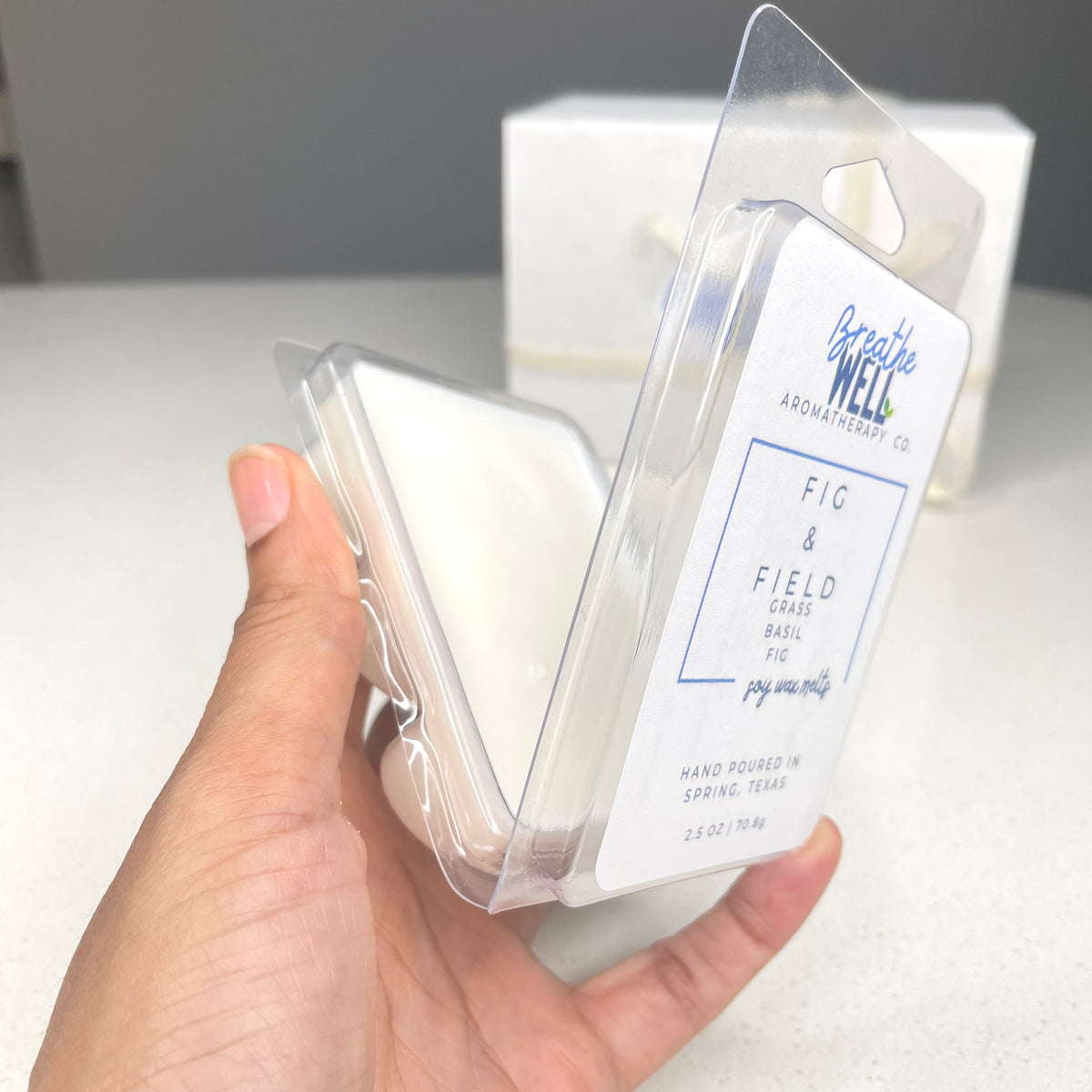 Fig & Field Soy Wax Melts in a plastic clamshell container with earthy scents of fresh grass, fig, and basil for a calming ambiance.