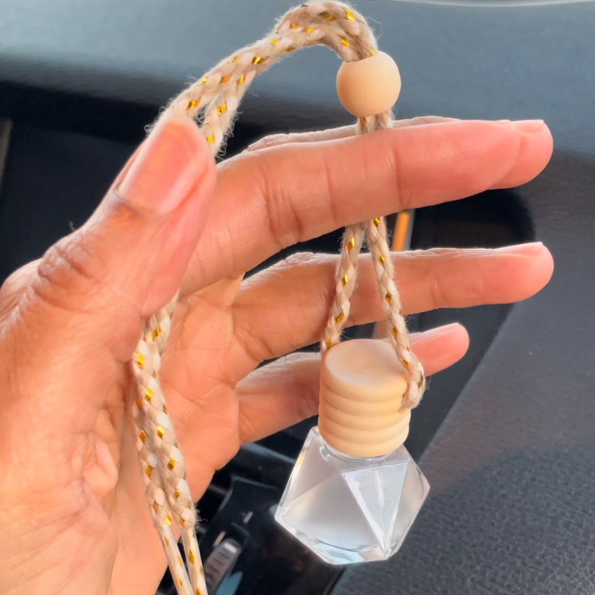 Hand holding essential oil car diffuser