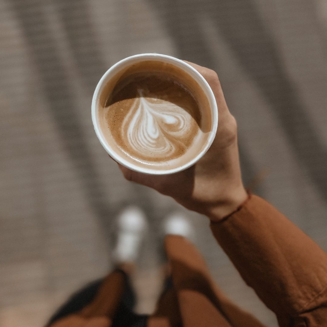 hand holding cup of coffee- Cozy Home Fragrance: Mocha Coffee Scented Soy Wax Melts Breathe Well Aromatherapy